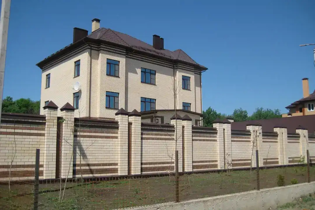 Забор и дом из белого и коричневого кирпич Железногорск
